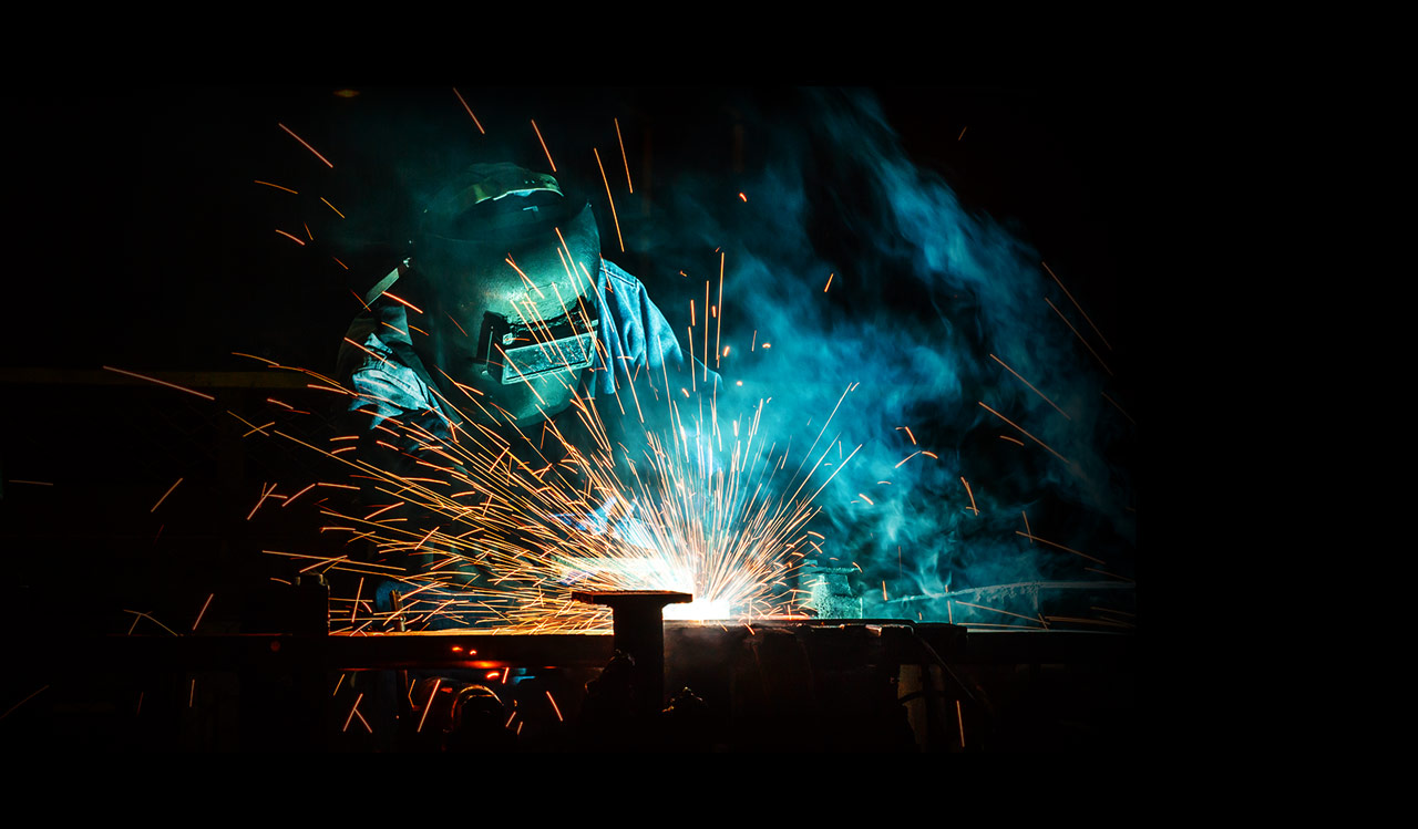 Worker is welding metal handrails on outdoor stairs, weld workflow, working process. Home and exterior, work near house.